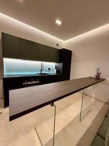 a kitchen with a long counter and a sink at H Luxury Apartment Crispi in Olbia +4 photos