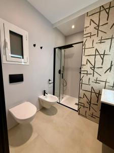 a bathroom with a toilet and a sink and a shower at H Luxury Apartment Crispi in Olbia