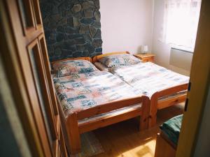 a bedroom with a wooden bed in a room at Zelená chalúpka a Zelený domček in Hrabušice
