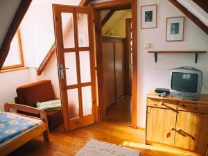 a room with a tv on a dresser with a door at Zelená chalúpka a Zelený domček in Hrabušice