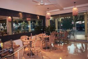a restaurant with tables and chairs and windows at Hotel Summer Frente Al Mar in Cartagena de Indias