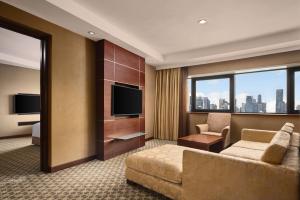 a hotel room with a couch and a television at Holiday Inn Singapore Atrium by IHG in Singapore