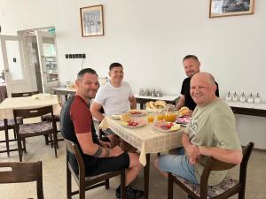 a group of men sitting at a table eating food at Kiss Villa in Balatonföldvár