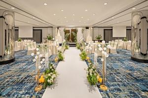a banquet hall with white chairs and a aisle with flowers at Holiday Inn Singapore Atrium by IHG in Singapore +124 photos