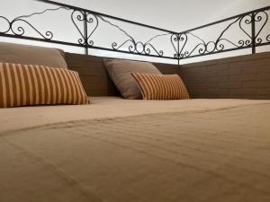 a bed with a headboard and pillows on it at Jasmin et Camomille in Roquebrun
