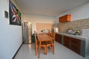 a kitchen with a table and chairs and a refrigerator at Villa Raksa Canggu in Canggu