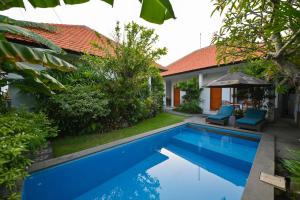 a villa with a swimming pool and a house at Villa Raksa Canggu in Canggu