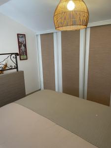 a room with a bed and a chandelier at Jasmin et Camomille in Roquebrun +12 photos
