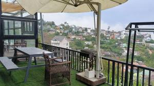 a balcony with a table and chairs and an umbrella at Homestay Lê Thảo in Ấp Ða Lợi