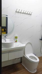 a white bathroom with a toilet and a sink at Homestay Lê Thảo in Ấp Ða Lợi +17 photos