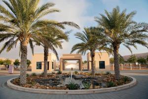 a courtyard with palm trees in front of a building at Arabian Nights Resort & Spa in Shāhiq