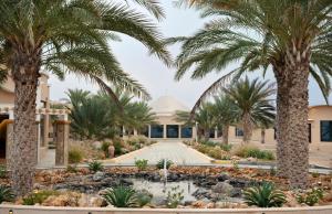 a view of a building with palm trees and a fountain at Arabian Nights Resort & Spa in Shāhiq