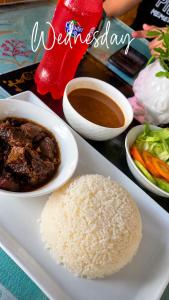 a plate of food with rice and a bowl of soup at bon Appetit Hotel restaurant barahona in Isleta de Barahona +5 photos