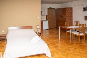 a bedroom with a bed and a table and chairs at Zawoja1560 Apartamenty przy Aptece in Zawoja
