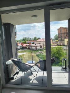 a screened porch with two chairs and a table at Mazury Glam Studio in Giżycko