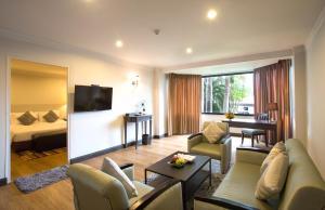 a hotel room with a couch and a bed and a table at The Imperial Hotel & Convention Centre Phitsanulok in Phitsanulok