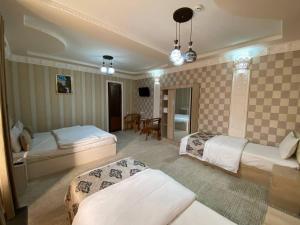 a hotel room with two beds and a table at El Emir in Samarkand