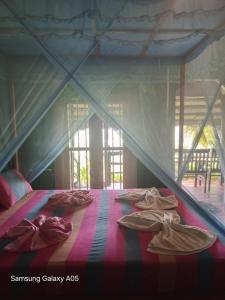 a room with a bed with pairs of shoes on it at Lake Face Cabana in Tissamaharama