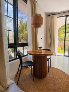 a table and chairs in a room with windows at Casa Mysa Villas in Michamvi