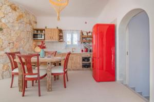 a kitchen with a table and a red refrigerator at Starlight Luxury Seaside Villa & Suites in Imerovigli