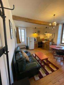 a living room with a leather couch and a table at Altitude 875 in Arrens-Marsous