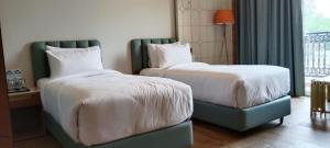 a hotel room with two beds and a window at Hotel Imperial Blu in Similigurha +14 photos