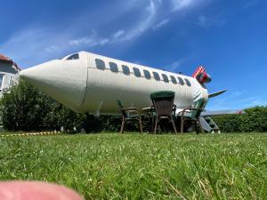 a plane sitting in the grass with two chairs at Sky Airplane in Tilburg