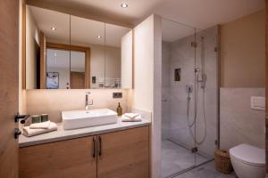 un bagno con lavandino e doccia di by franz - Alpine Apartments in Kirchberg a Kirchberg in Tirol Altre 41 foto