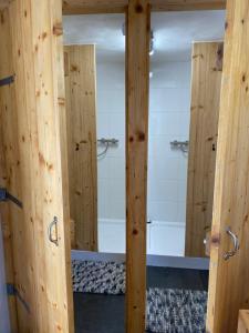 a bathroom with two wooden doors and a shower at Sky Airplane in Tilburg