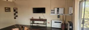 a room with two refrigerators and a tv on the wall at Khoneni in Marloth Park