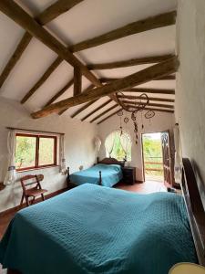 a bedroom with two blue beds in a room at Hotel el Amanecer in Samaipata
