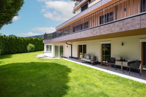 un cortile sul retro di un edificio con un prato di by franz - Alpine Apartments in Kirchberg a Kirchberg in Tirol
