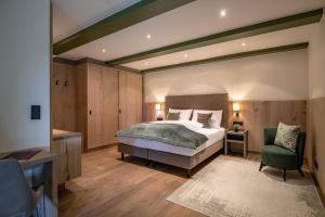 una camera da letto con un grande letto e una sedia verde di by franz - Alpine Apartments in Kirchberg a Kirchberg in Tirol