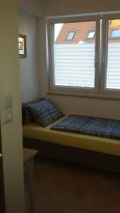 a small room with two beds and a window at Fino da Mario in Ebersbach an der Fils