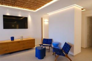 a room with two blue chairs and a wooden cabinet at Grand Beach Hotel in Mikonos