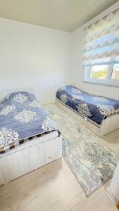 a bedroom with two beds and a window at Тосор конок үйү AJ in Tossor