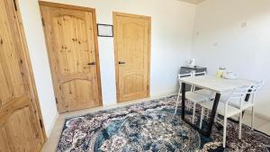 a room with a table and two wooden doors at Тосор конок үйү AJ in Tossor