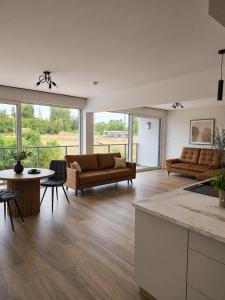 a living room with two couches and a table at Olimp Apartamenty in Konin