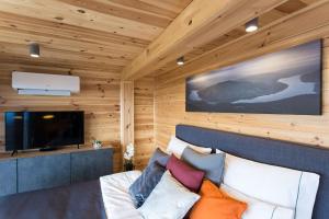 a room with a bed and a flat screen tv at Szarvashegy Panoráma Apartman in Szentendre