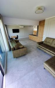 a living room with two couches and a tv at Olimp Apartamenty in Konin