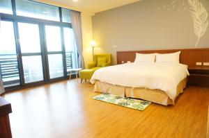 Habitación de hotel con cama y silla en Mulin B&B en Hengchun