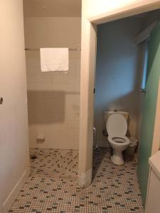 a bathroom with a toilet and a tiled floor at Pacific Cay motel in Cairns North +9 photos