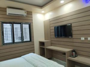 a bedroom with a bed and a tv on a wall at Hotel lakshmi in Goddā