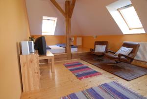 a living room with a tv and two chairs at Penzion Dvůr in Obora