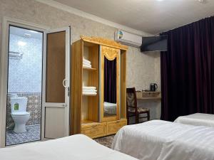 a hotel room with two beds and a bathroom at El Emir in Samarkand