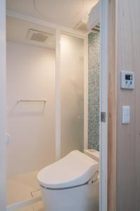 a bathroom with a white toilet and a shower at glampark Sesoko -Ocean Terrace- in Sesoko