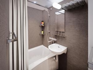 a bathroom with a sink and a tub and a toilet at Mercure Niseko Resort Formerly known as Midtown Niseko in Kutchan