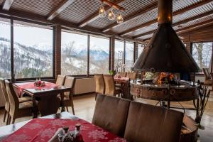 a dining room with a fireplace and a view of mountains at Cabana Trei Brazi in Predeal +62 photos