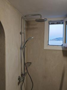 a shower in a bathroom with a window at Troulou beach house in Kimolos