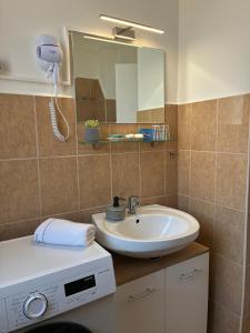 a bathroom with a sink and a mirror at AeraSuites Komárom in Komárom